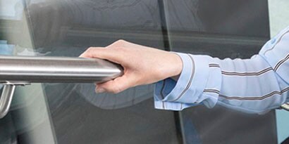 woman’s hand on a stair banister that has been disinfected with 3m cleaning products
