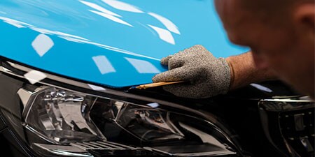 Aplicator installing car wrap vinyl
