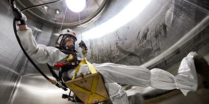 A worker in coverall in a confined space

