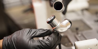 Learn about material bonding. Image of metal pipe being bonded with liquid adhesive.

