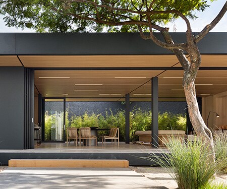 Exterior of modern home with matte black and light wood finishes
