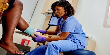 health care provider checking a venous leg ulcer
