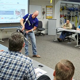 A male in a blue t-shirt delivering training  