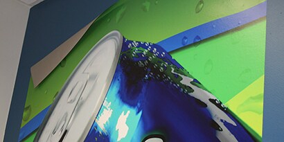 Peeling down 3M low-VOC paint wall graphic of soda can with condensation
