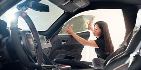 Woman applying window tinting

