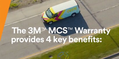 birds-eye view of a van wrapped in a colorful graphic driving down a street
